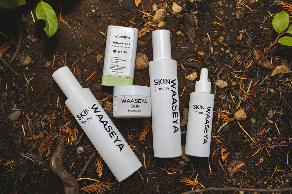 Set of Waaseya skincare products on a natural background with soil and leaves.